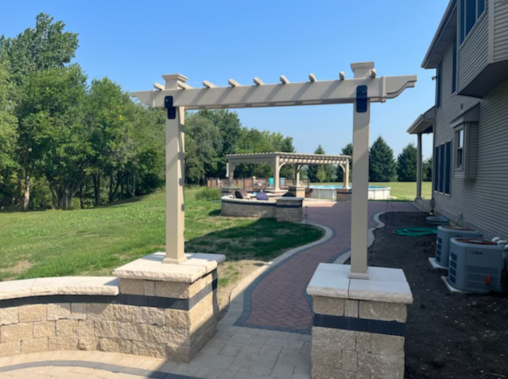 A pergola is in the backyard of a house