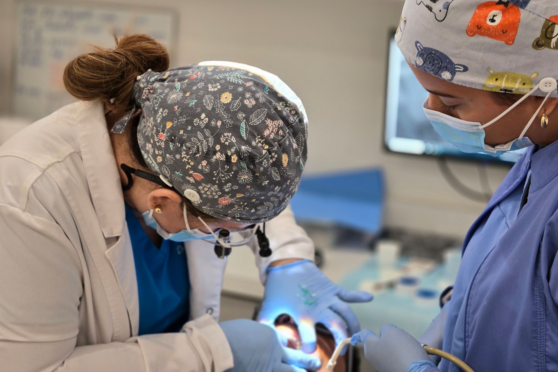 A dentist and a nurse are working on a patient 's teeth.