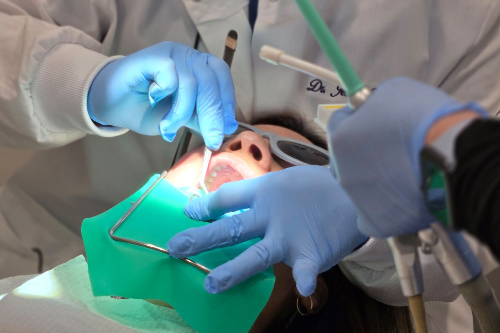 A dentist is examining a patient's teeth in a dental office.