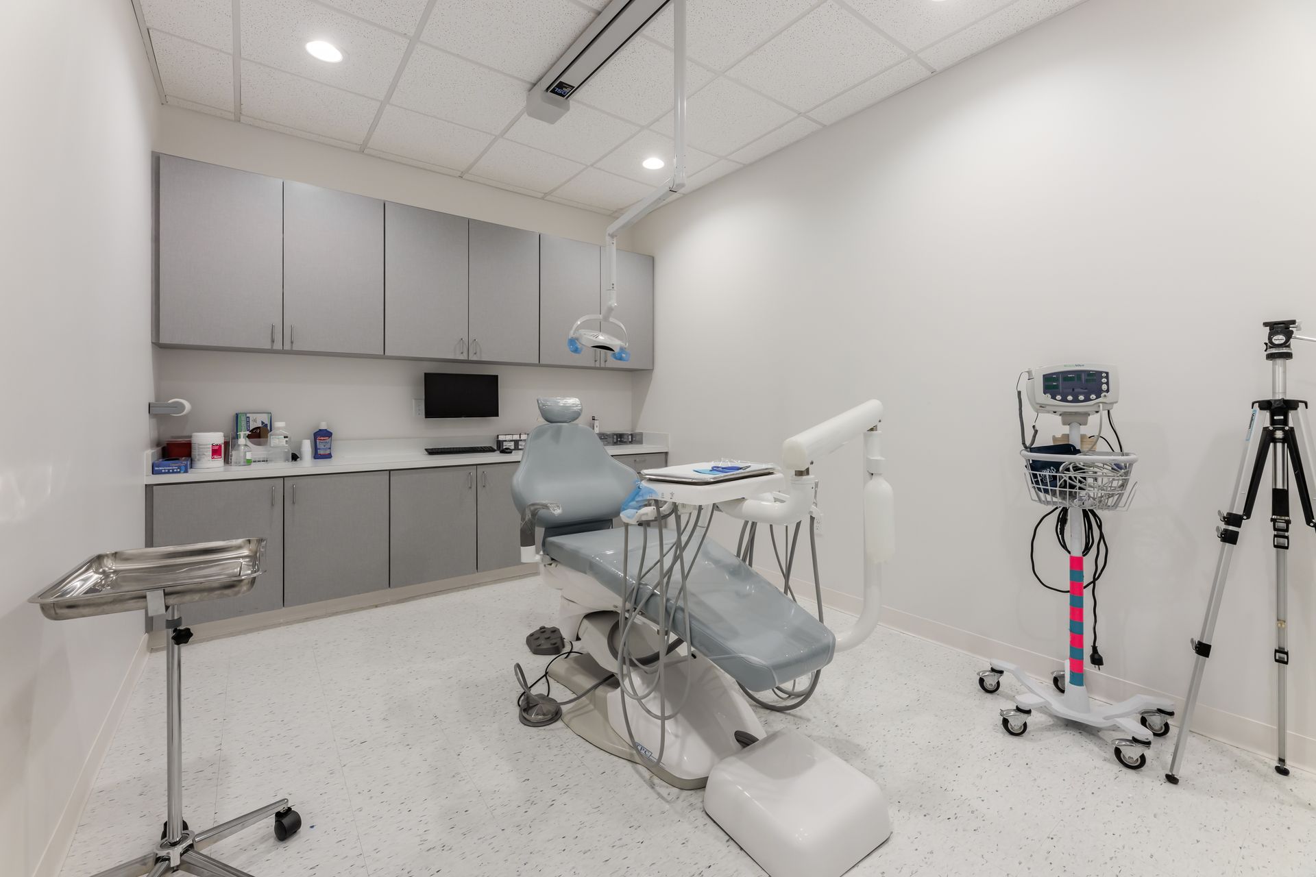 There is a dental chair in the middle of the room.