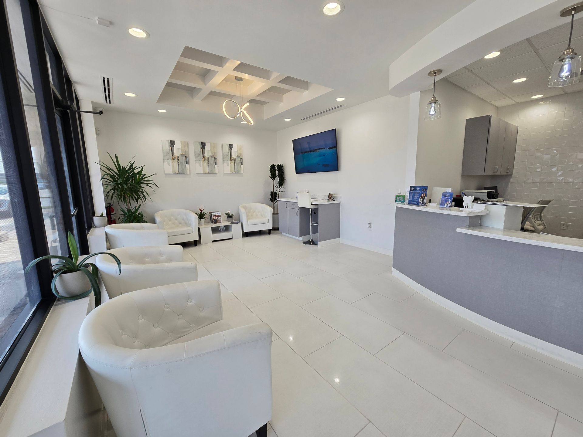 A waiting room with chairs and a counter in a dental office.