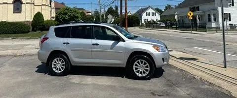 Silver SUV parked at the edge of a street intersection on a sunny day