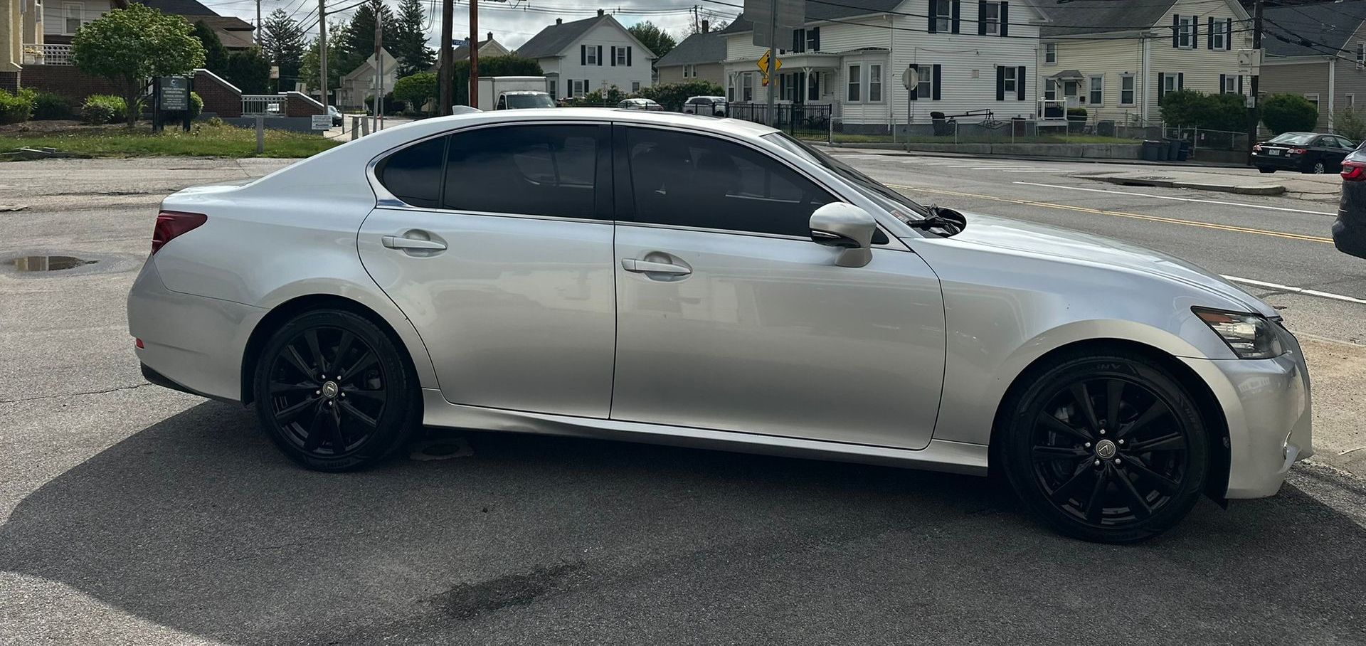 Silver sedan parked on a street in a residential neighborhood