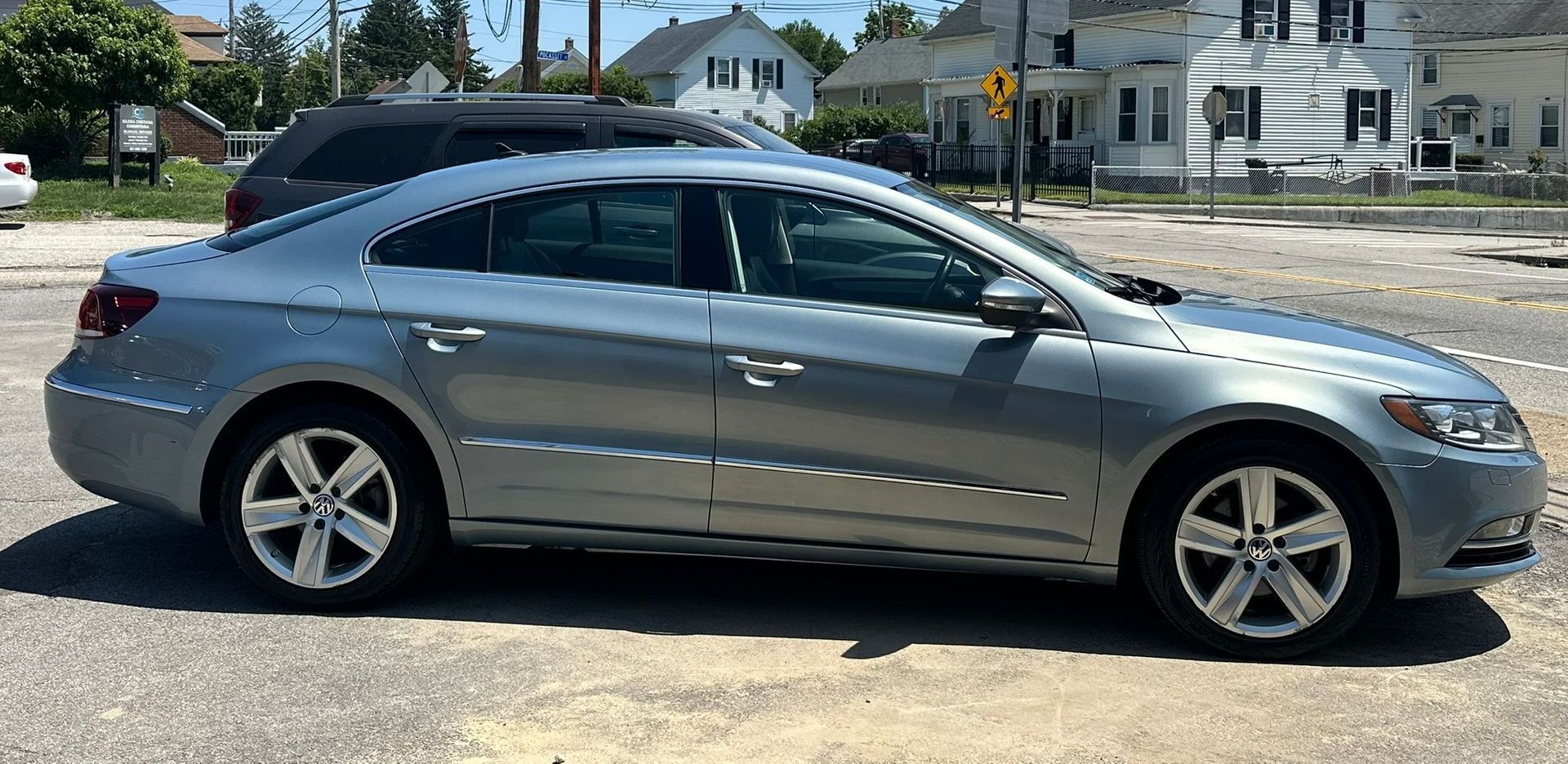 Silver sedan parked on a street near an intersection on a sunny day