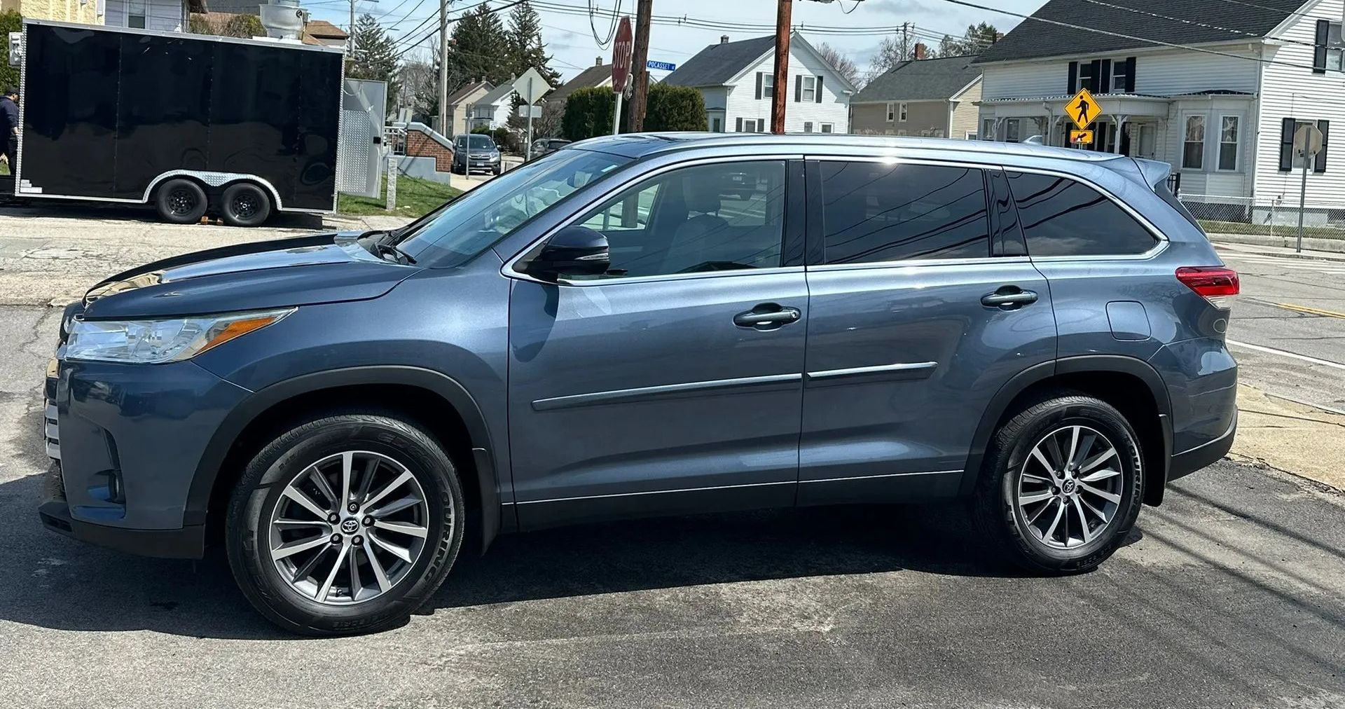 Blue SUV parked on a street at an intersection in daylight