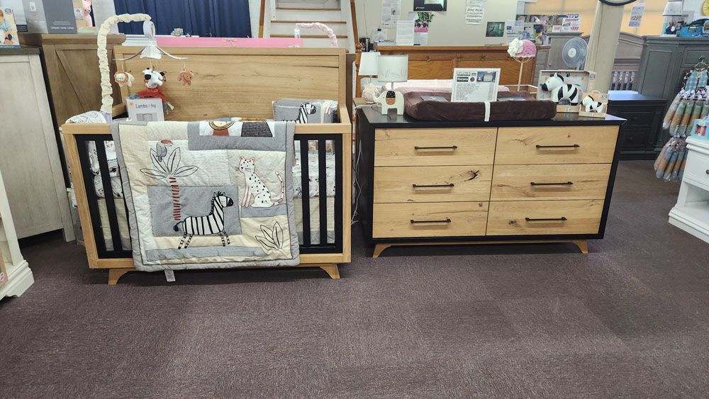 A crib and dresser are sitting next to each other