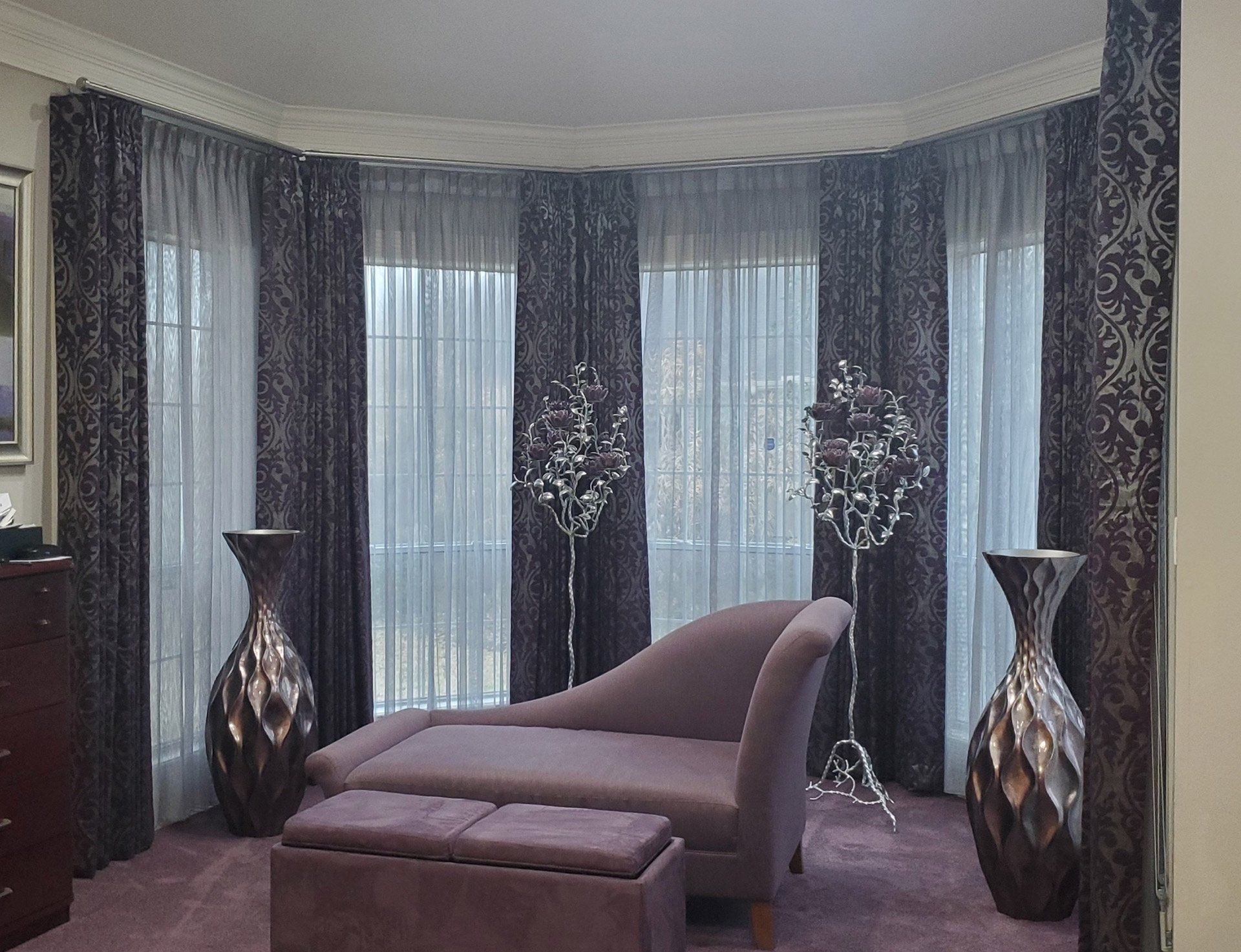 A living room with purple curtains and a purple chaise lounge