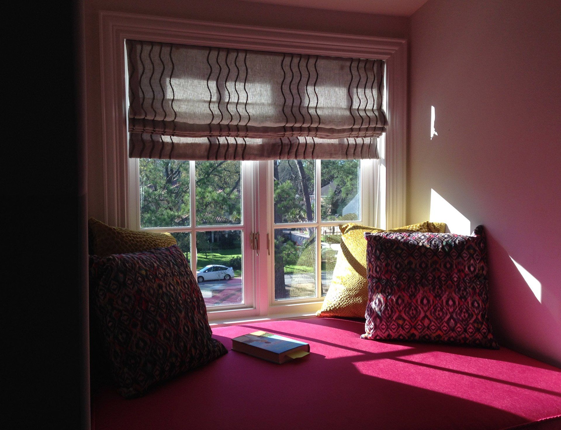 A window seat with pillows and a book on it