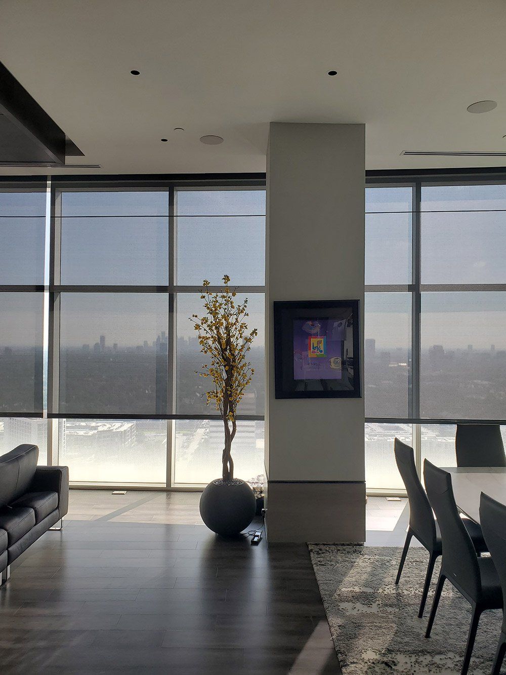 A living room with lots of windows and a tv on the wall
