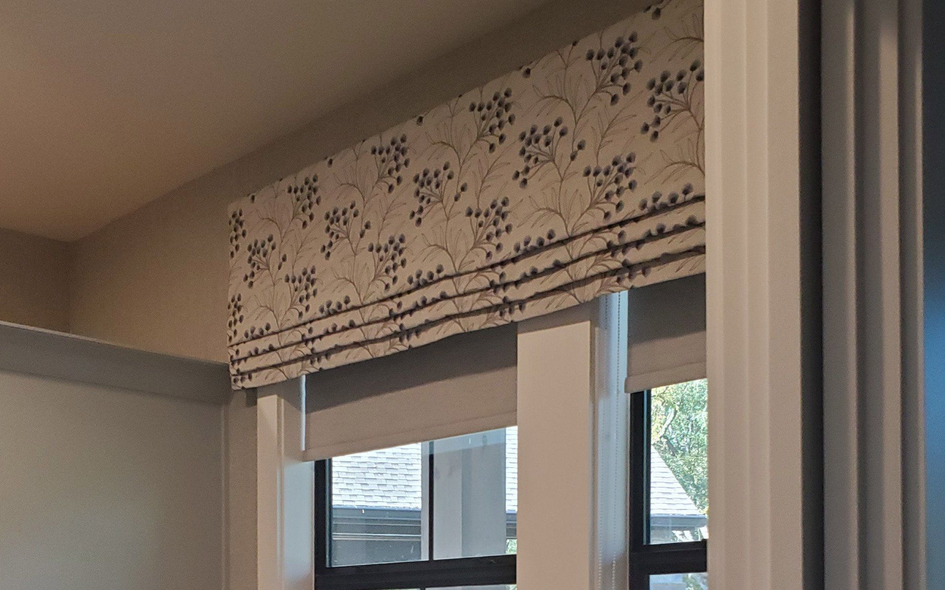 A window with a roman shade on it in a room.