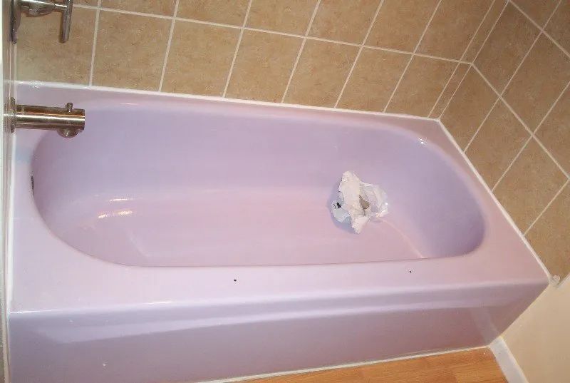 a purple bathtub in a bathroom with tile walls