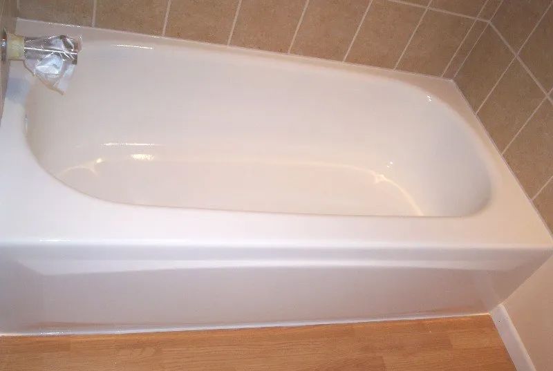 a white bathtub is sitting in a bathroom next to a tiled wall