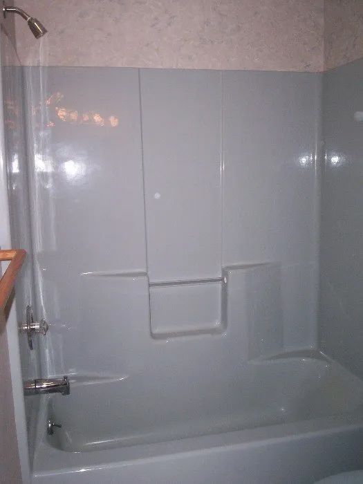 a bathroom with a bathtub , shower and toilet