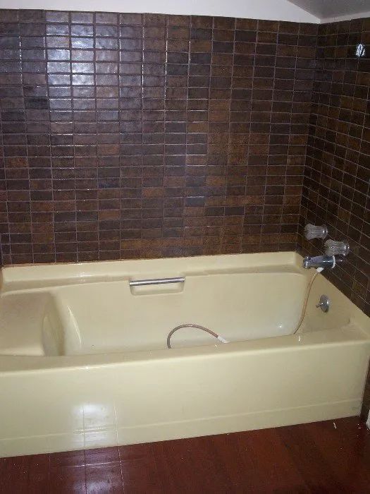 a bathtub in a bathroom with brick walls