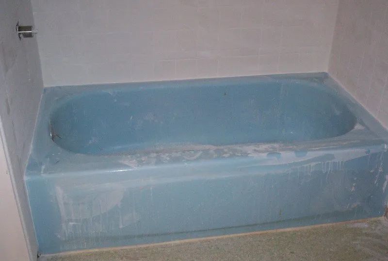 a blue bathtub is sitting in a bathroom next to a white wall