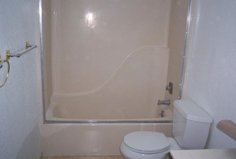 a bathroom with a toilet, tub and shower