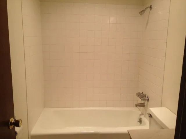 a bathroom with a bathtub , toilet and shower