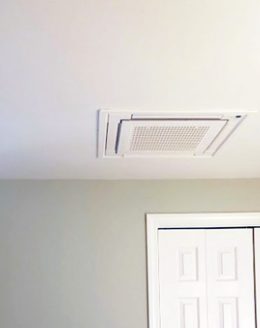 Ceiling air vent above a white door in a light-colored room