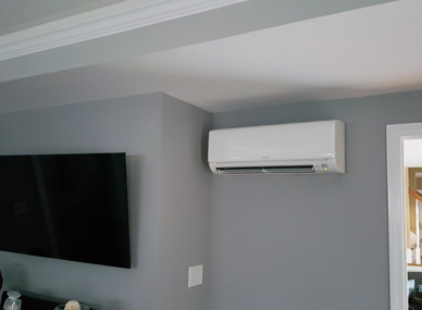 Gray living room wall with wall-mounted TV and white air conditioner above a doorway