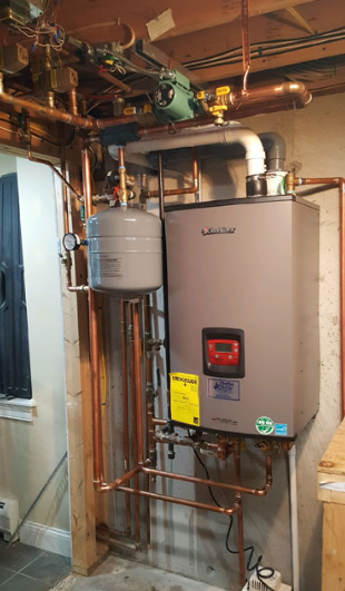 Water heater and boiler unit with exposed copper pipes in a utility room