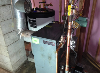 Basement boiler and copper pipes beside a water heater and furnace unit.