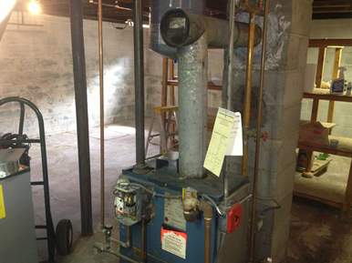 Vintage blue machine with a tall pipe and a yellow note in a museum display room