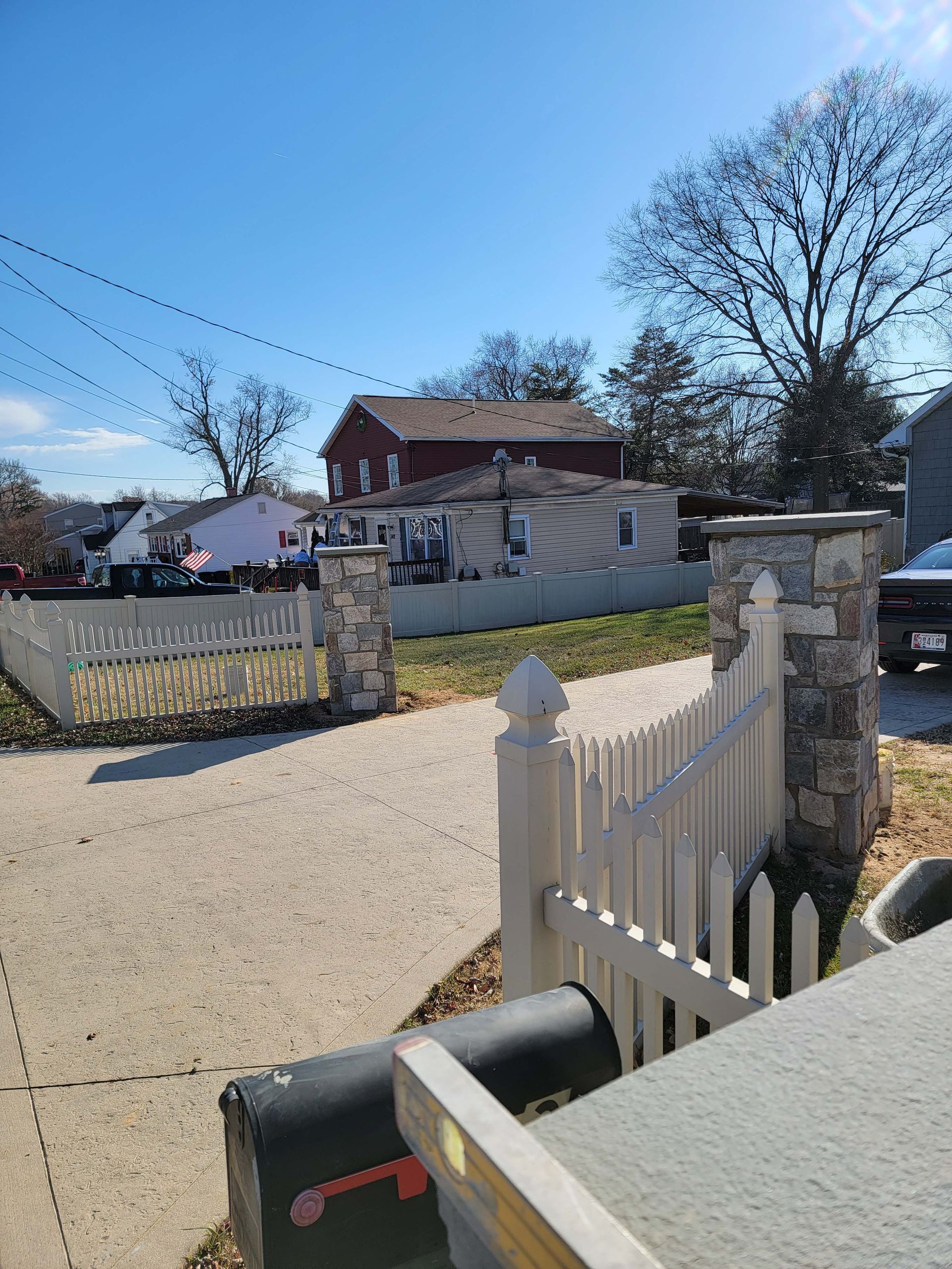 a white picket fence with a mailbox in front of it