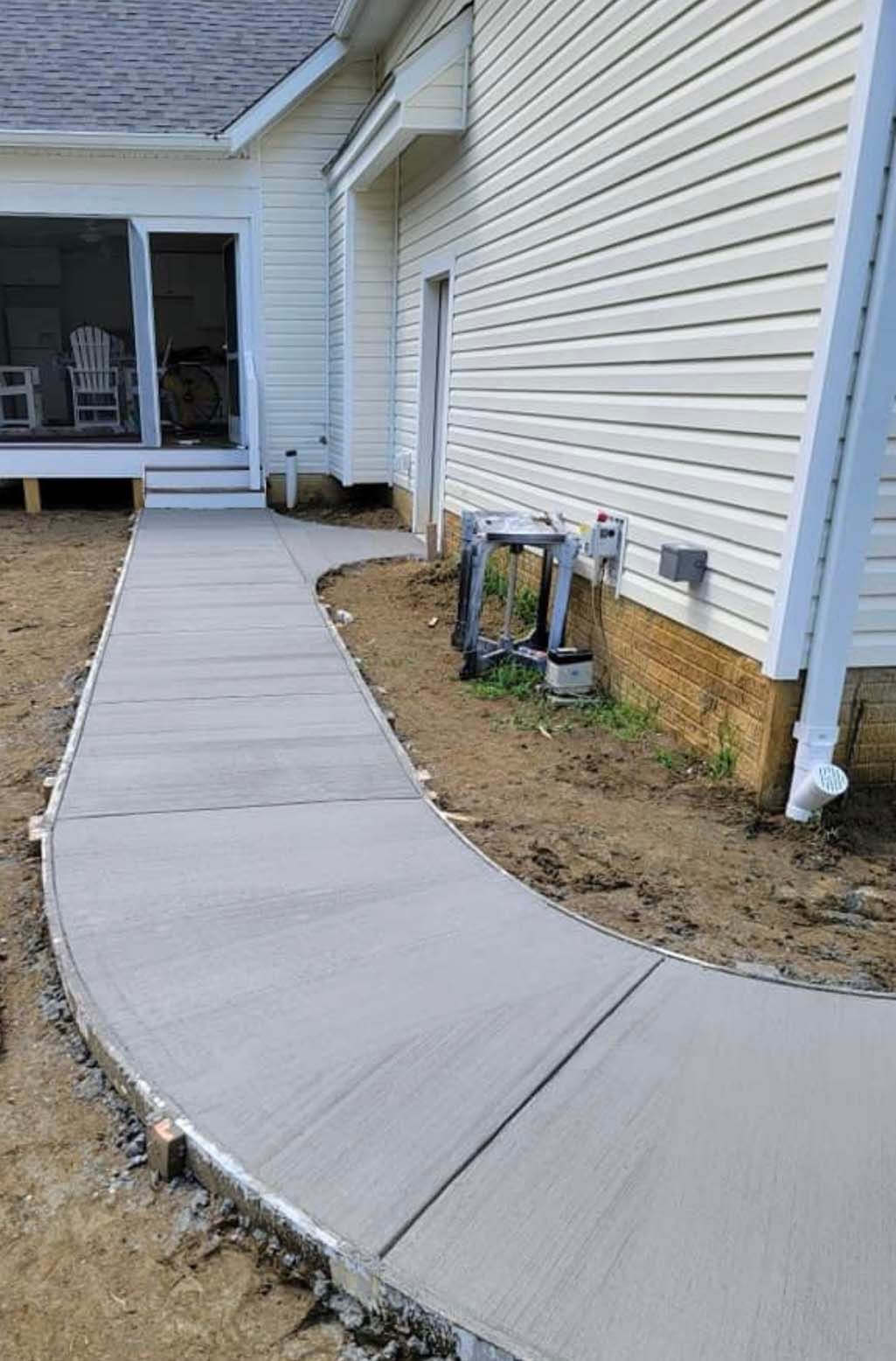 a concrete walkway is being built in front of a house .