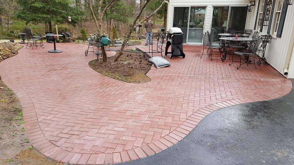 a brick patio with tables and chairs in front of a house .
