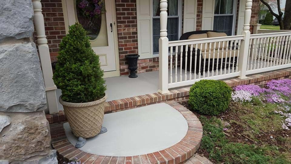 there is a potted plant on the porch of a house .