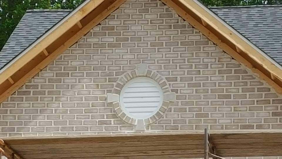 a brick wall with a round window and a wooden roof .