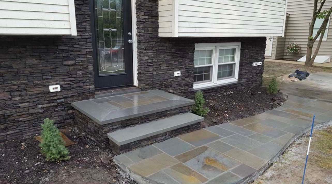 a stone walkway leading to the front door of a house .