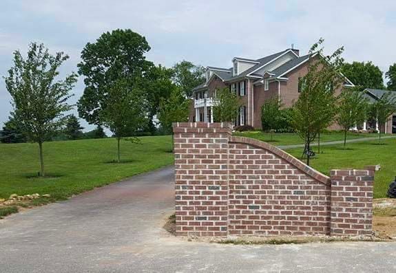 a large house with a brick wall in front of it