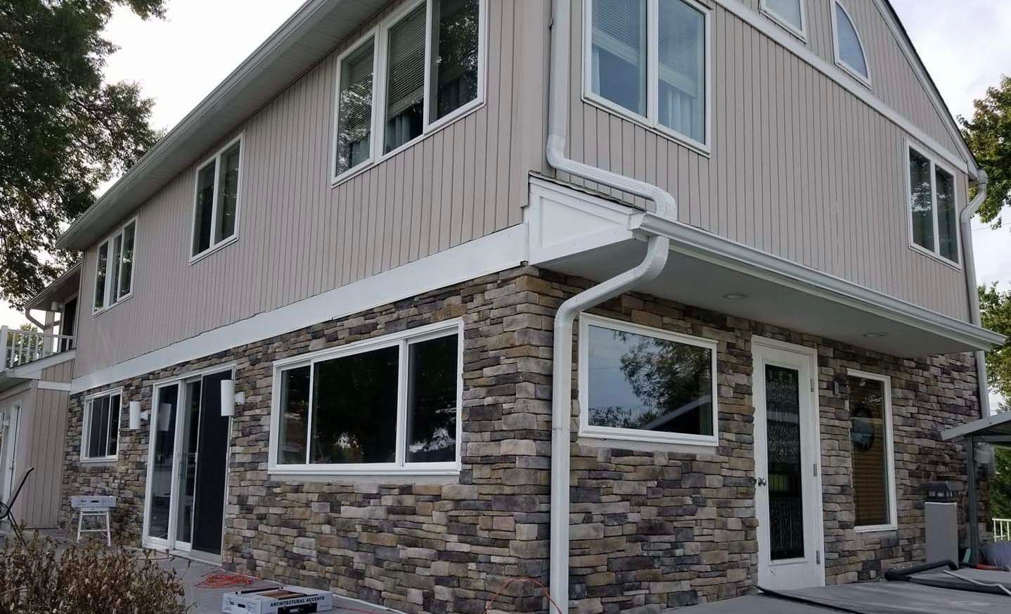 a large house with a lot of windows and a stone facade .