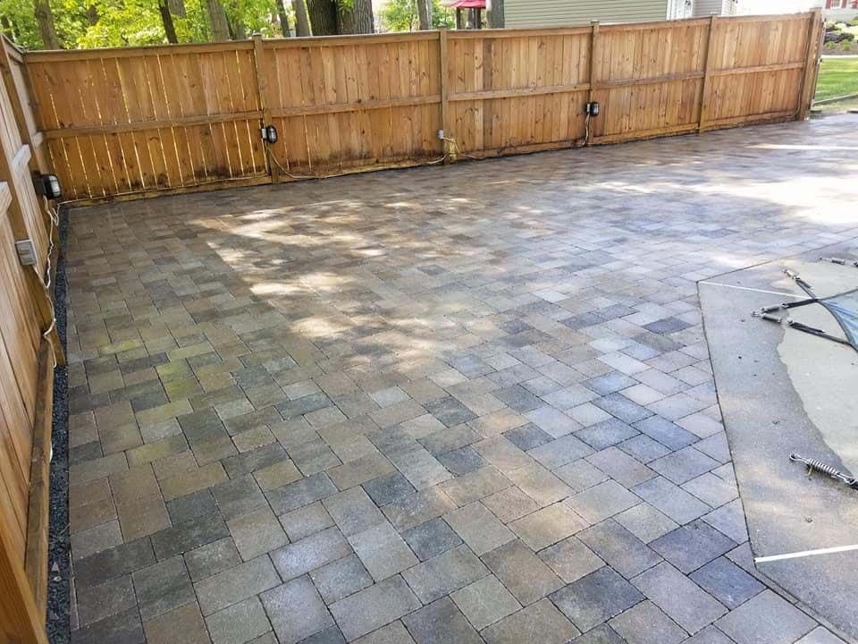 a brick patio with a wooden fence in the background .
