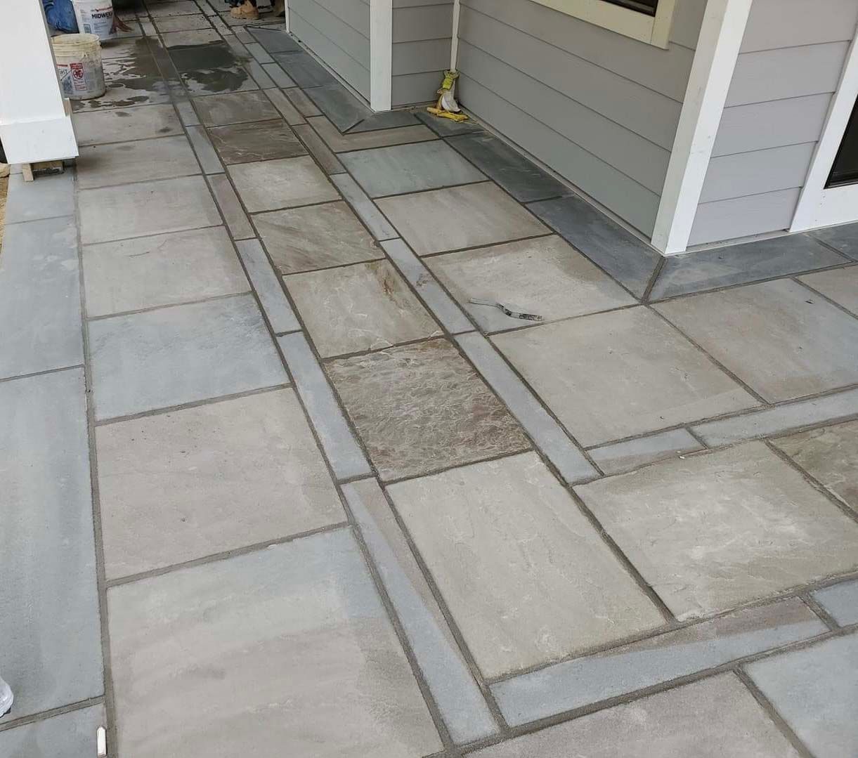 a concrete walkway with a white house in the background