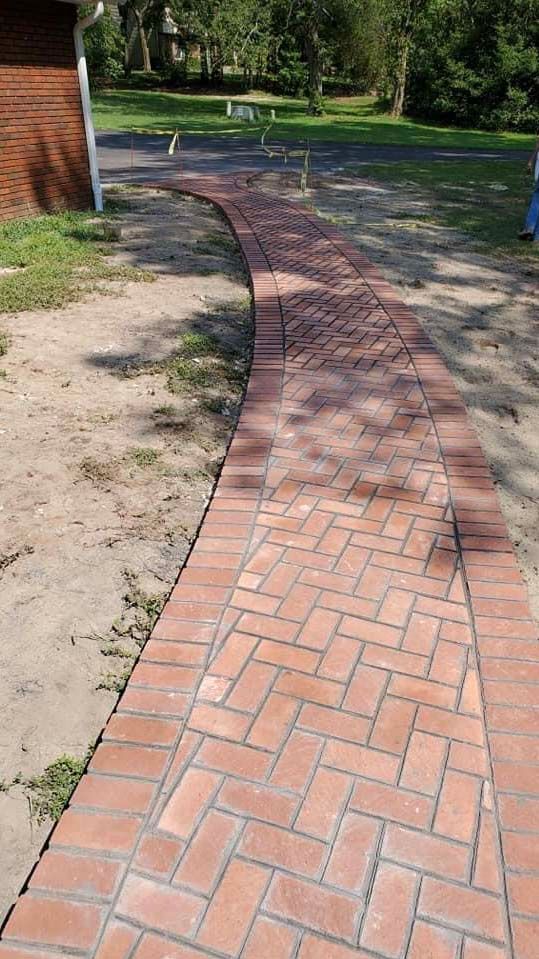 a brick walkway is being built in a herringbone pattern .