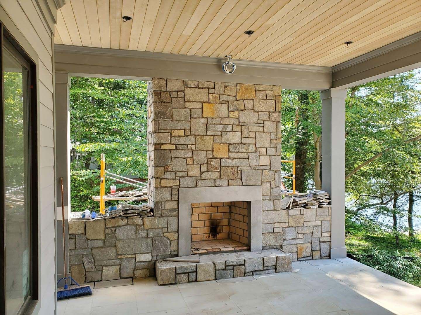 a stone fireplace is under construction on a porch .