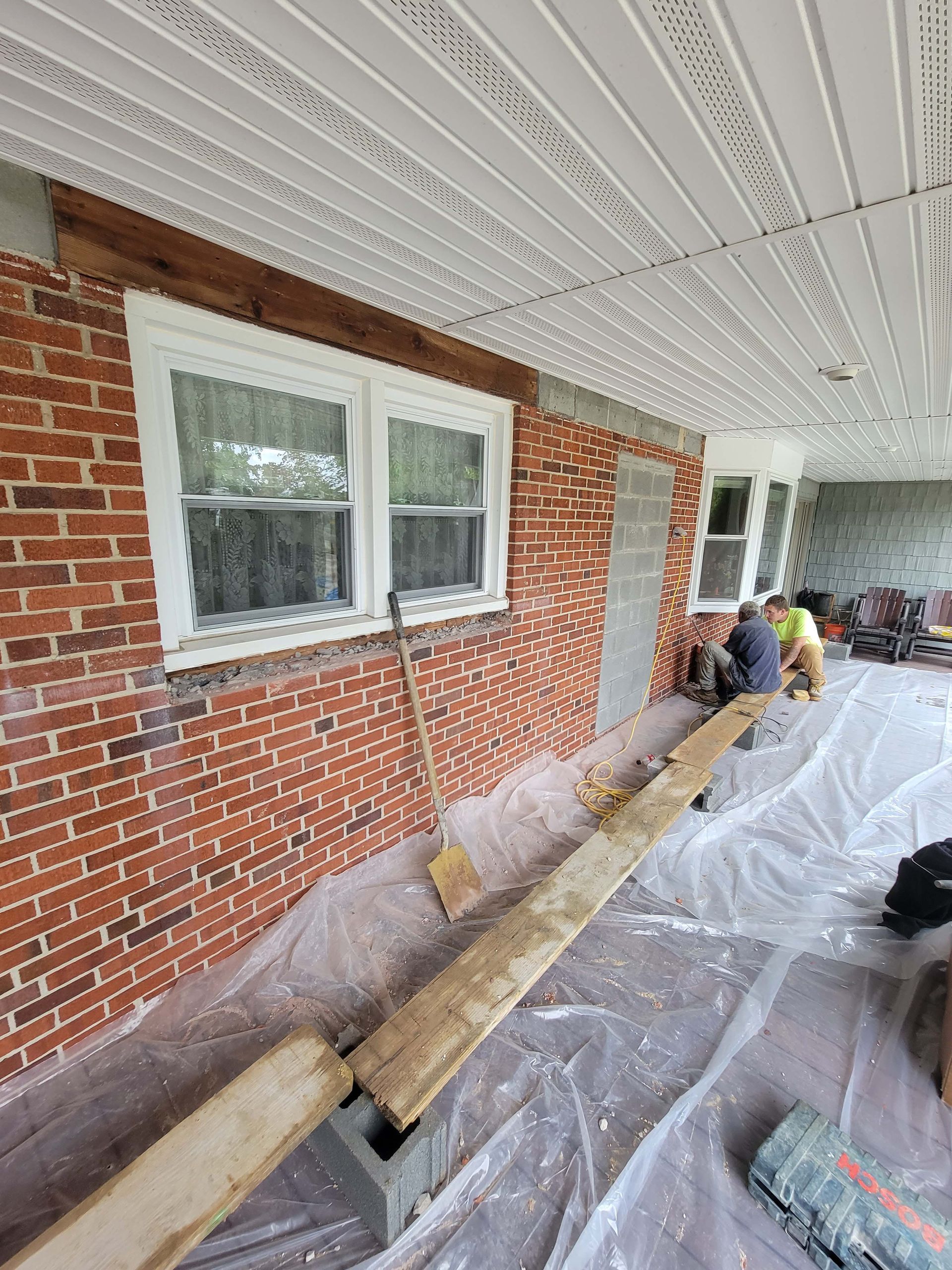 a man is sitting on a bench in front of a brick building .