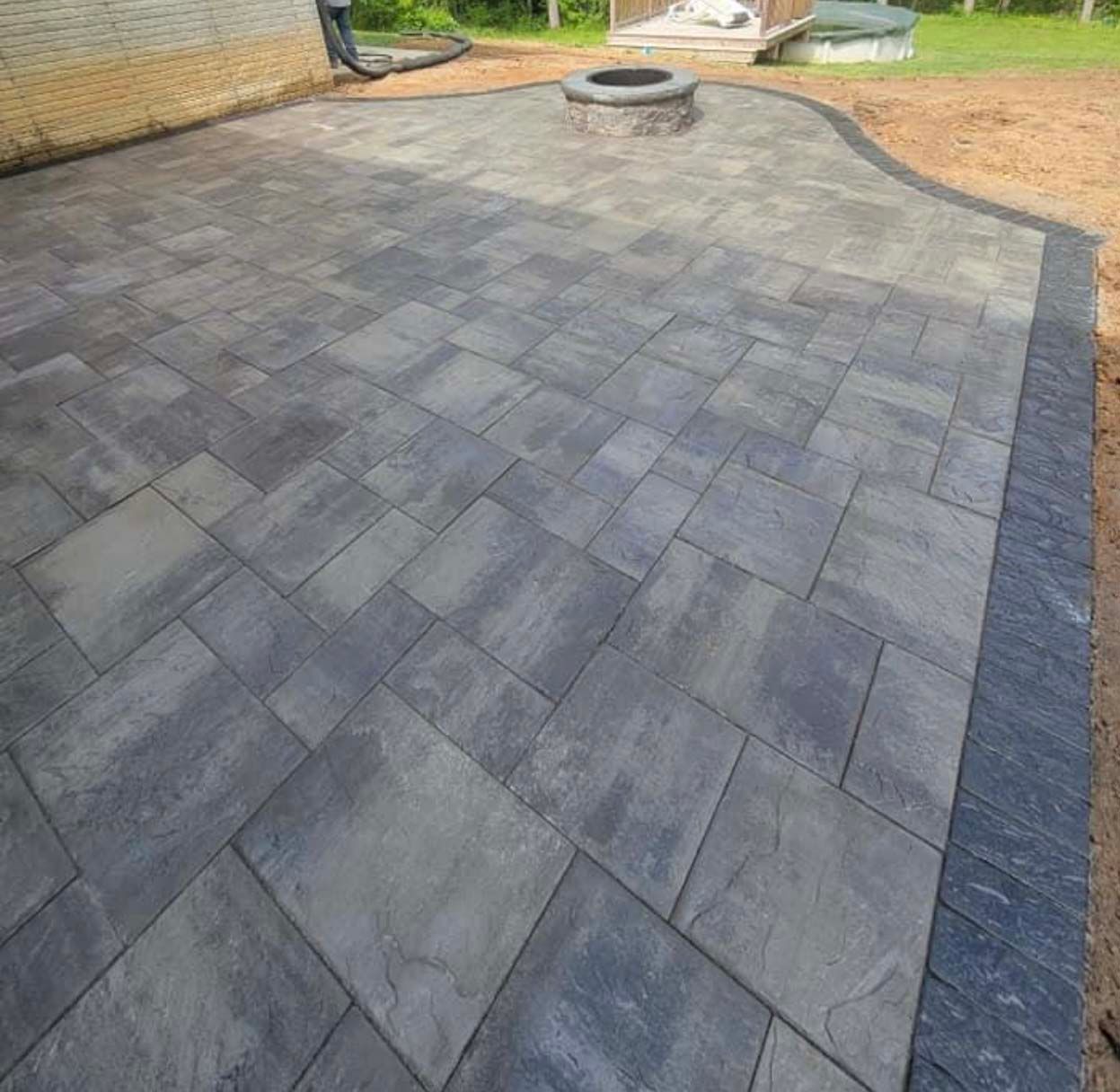 a patio with a fire pit in the middle of it .