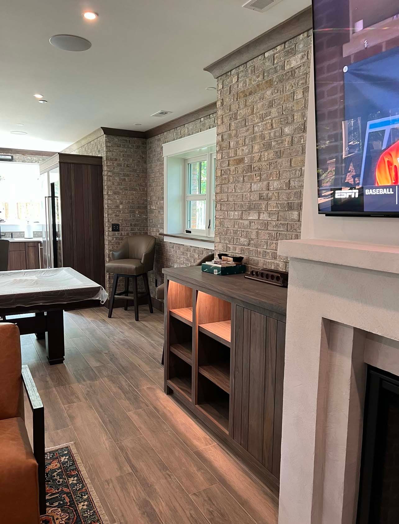 a living room with a pool table and a television on the wall .