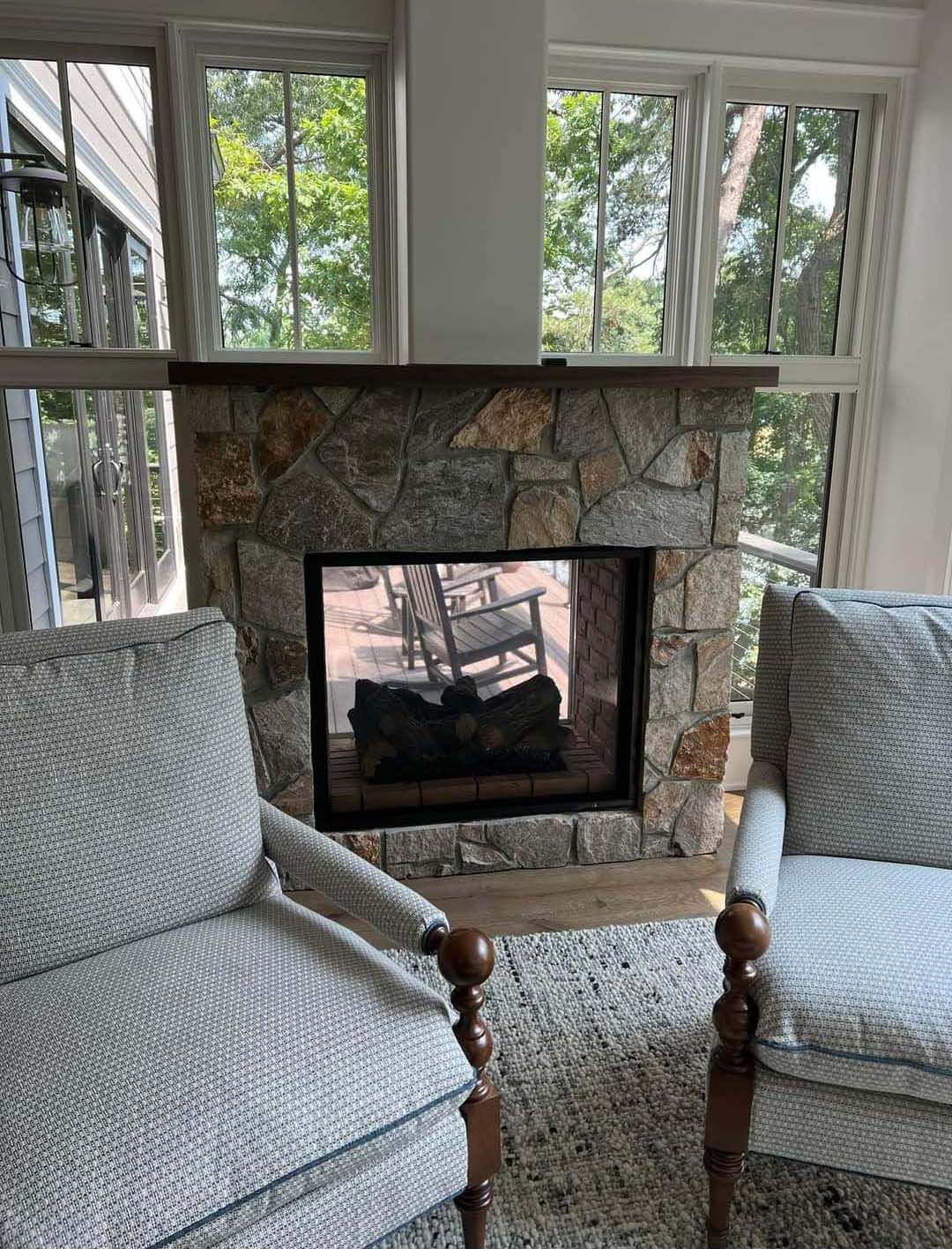 a living room with two chairs and a fireplace .