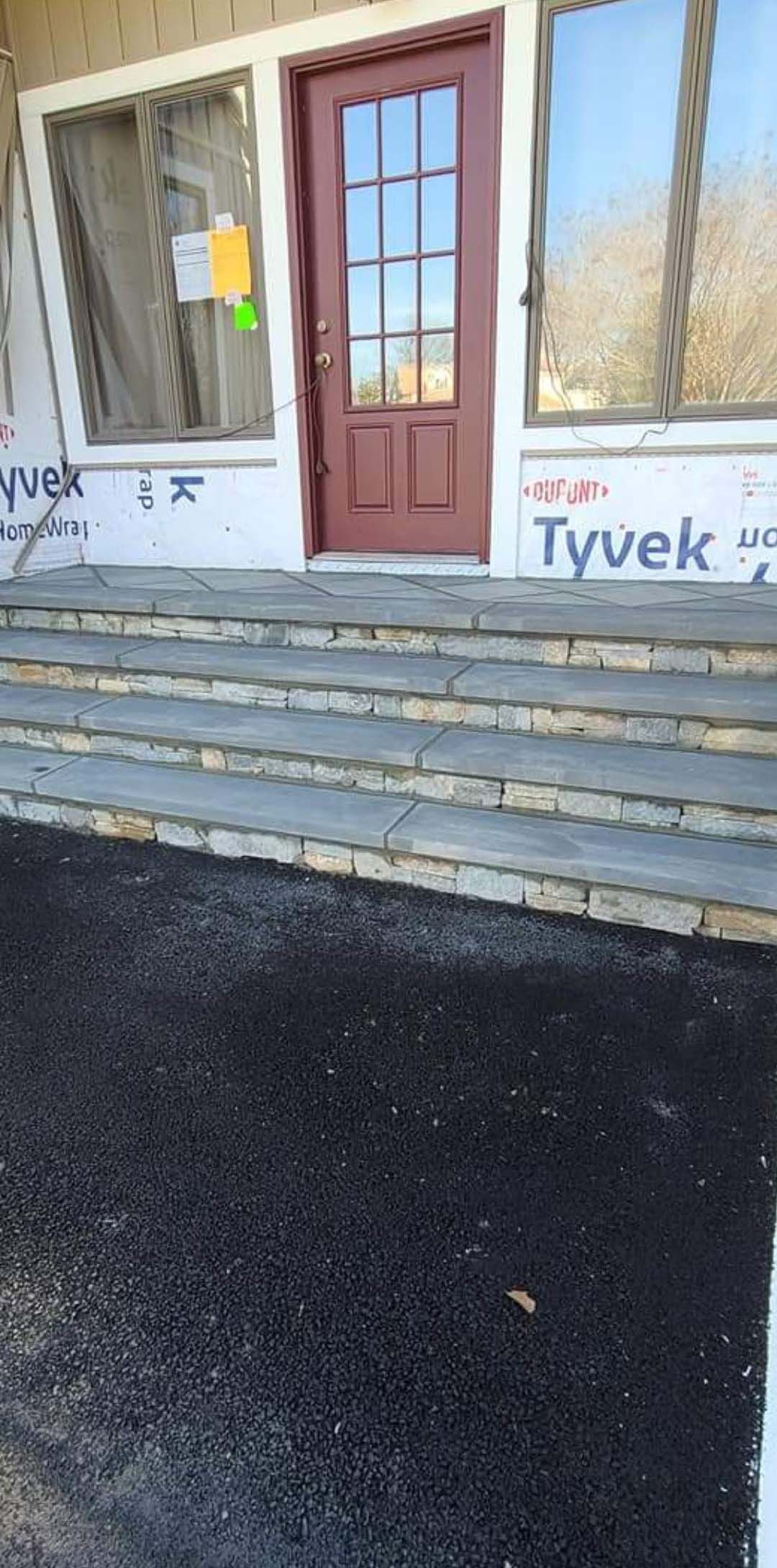 a red door is sitting on top of a set of stairs .