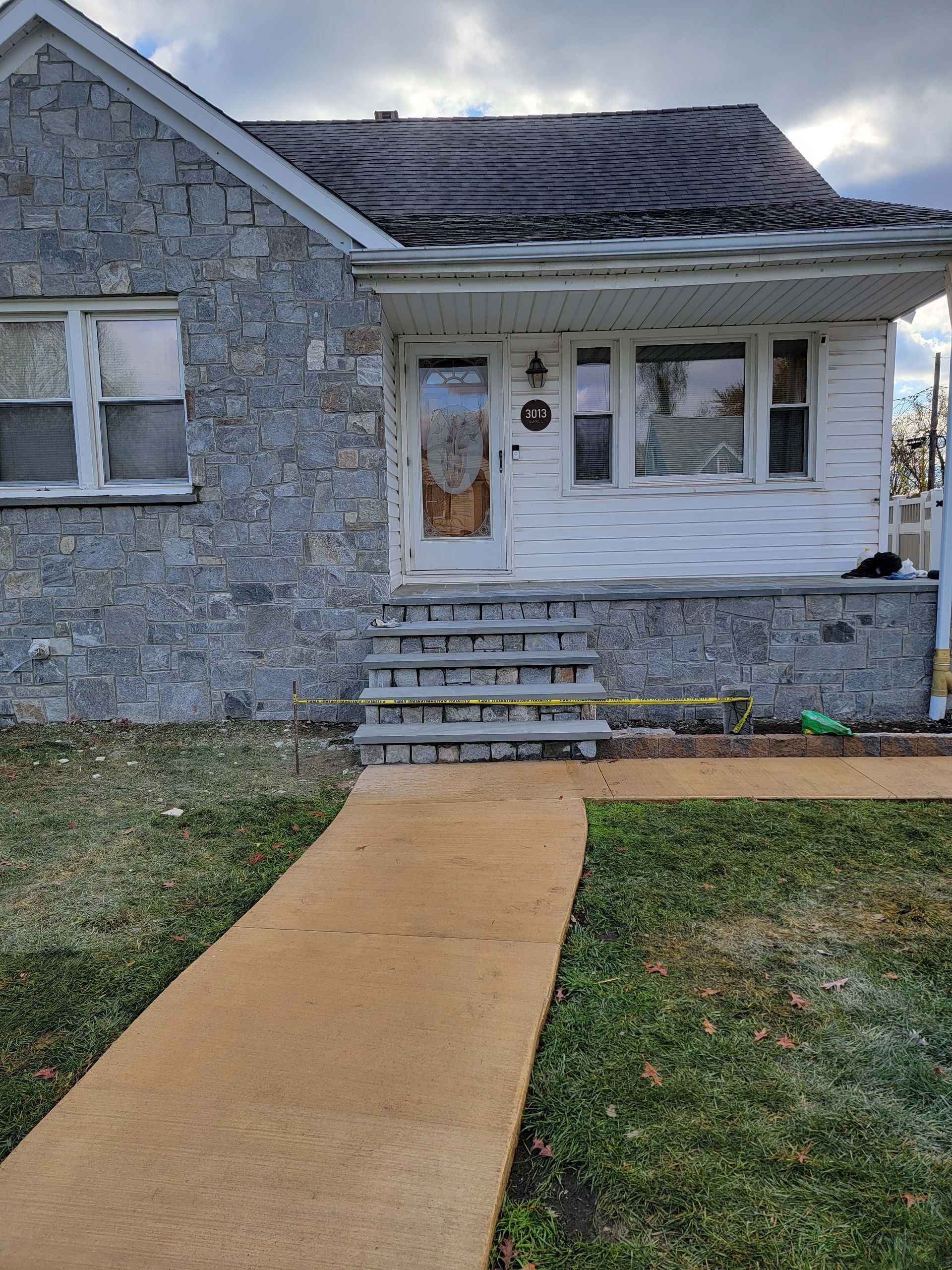there is a walkway leading to the front of the house .