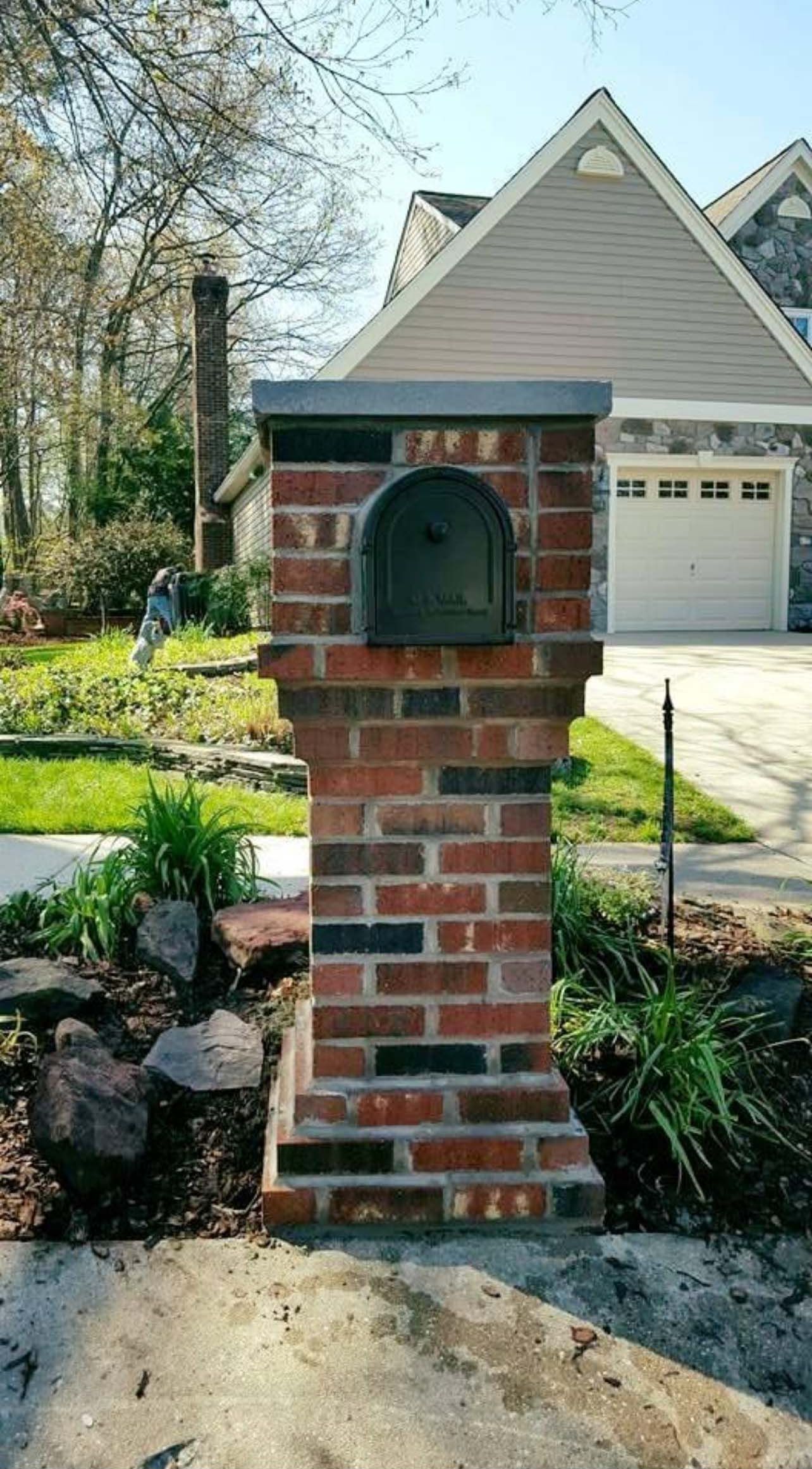a brick mailbox is in front of a house .