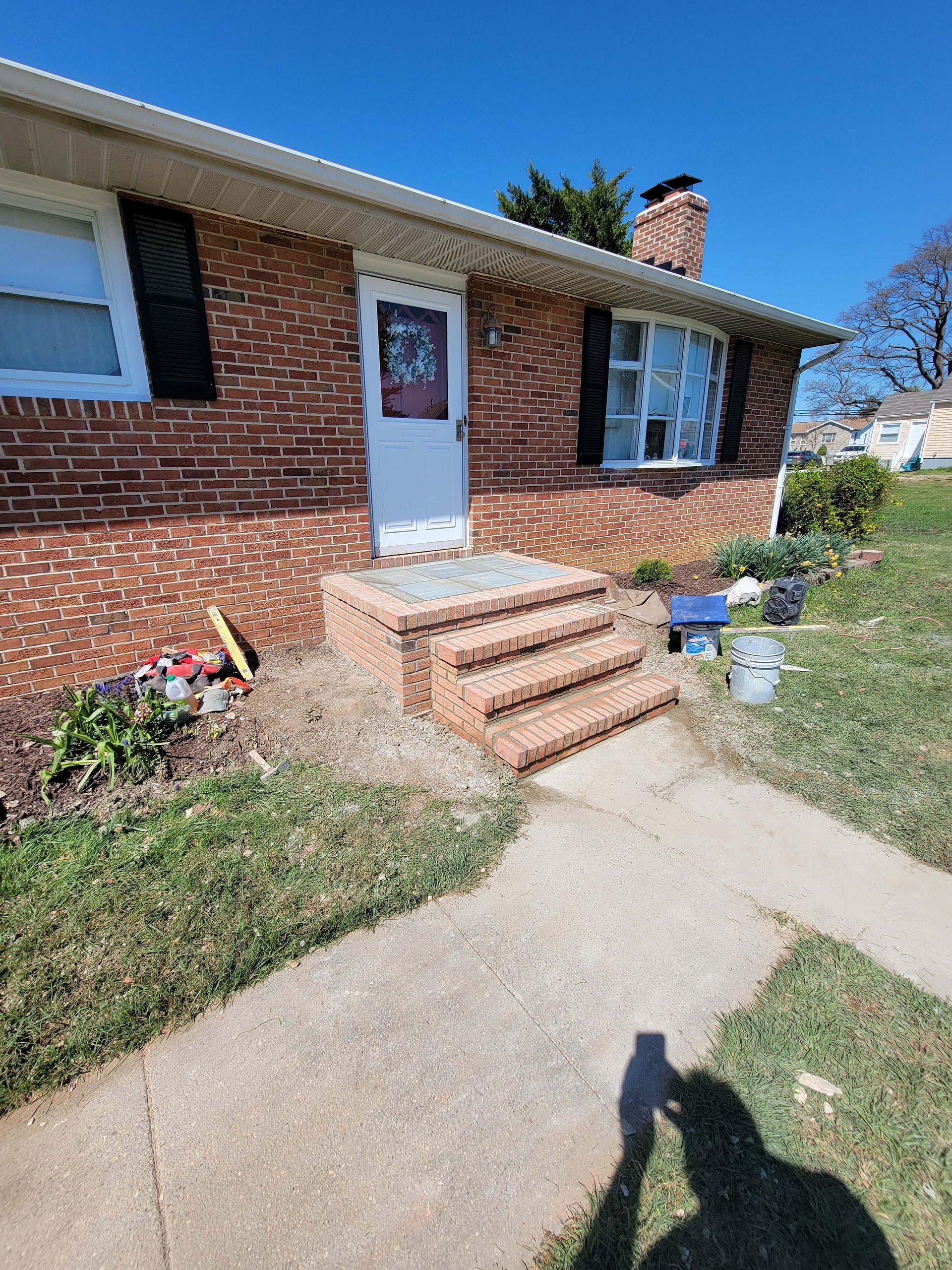 a brick house with stairs leading up to the front door .