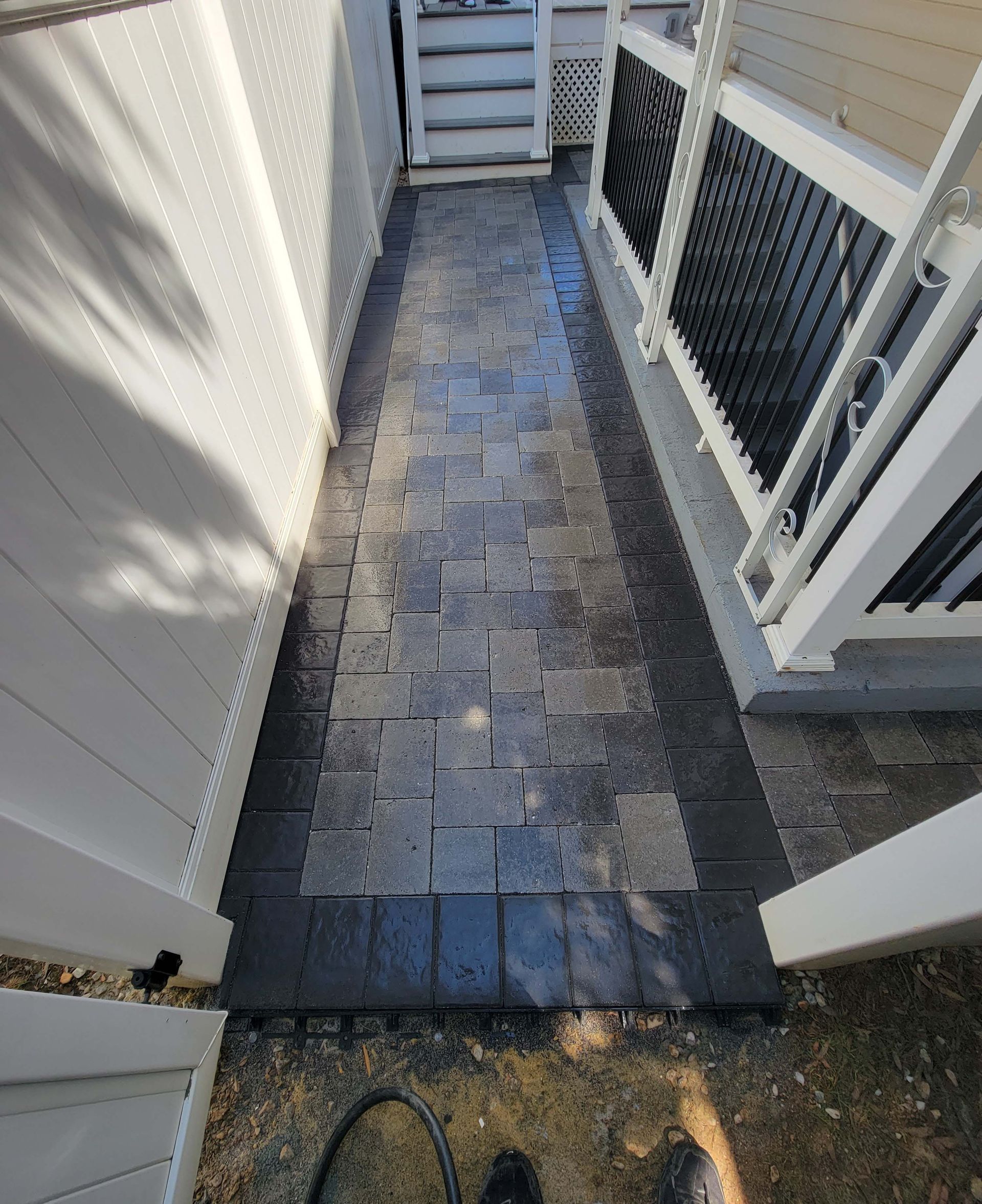 a walkway between two buildings with a white fence .