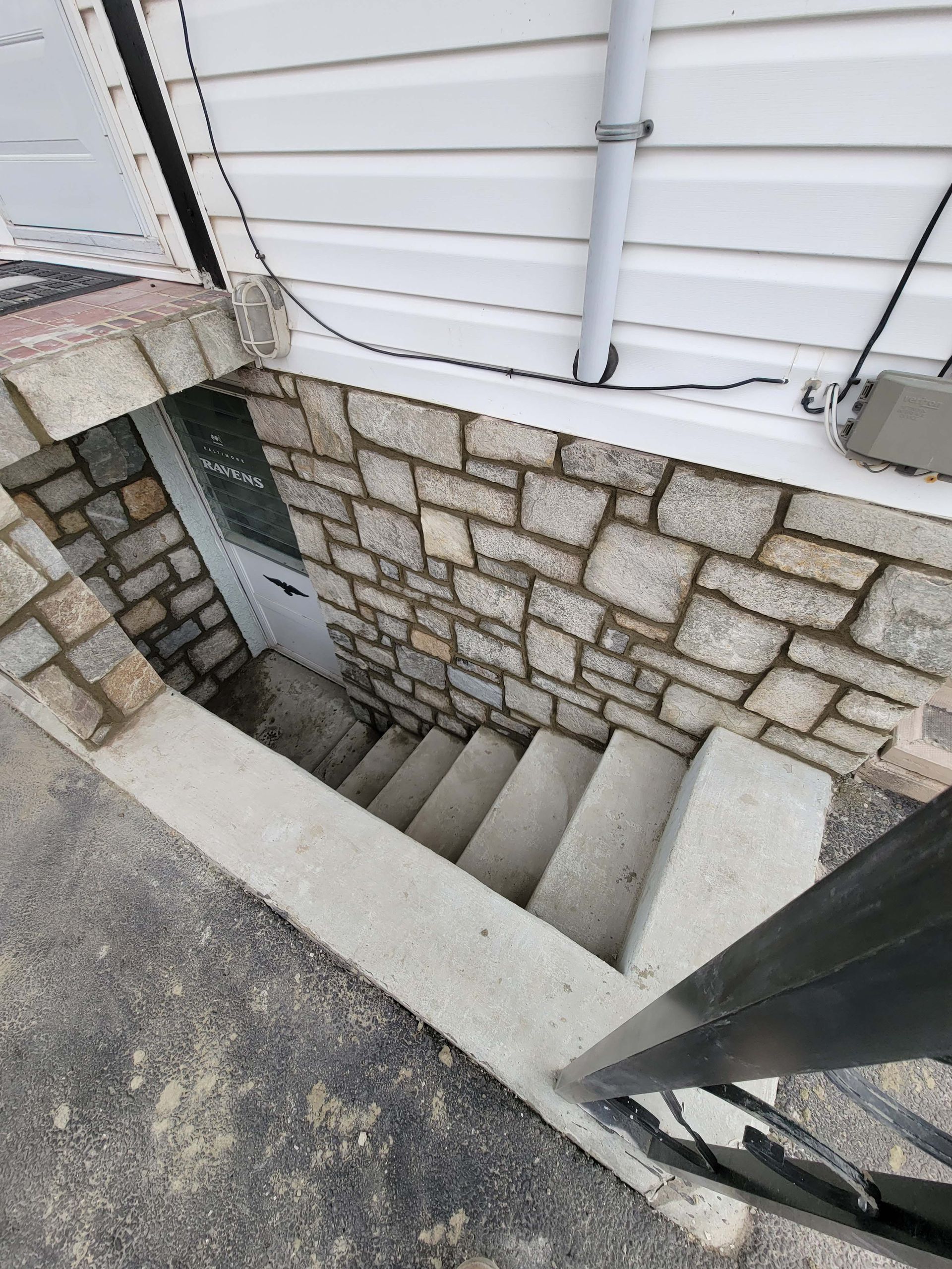 a stone wall with stairs leading up to a basement .