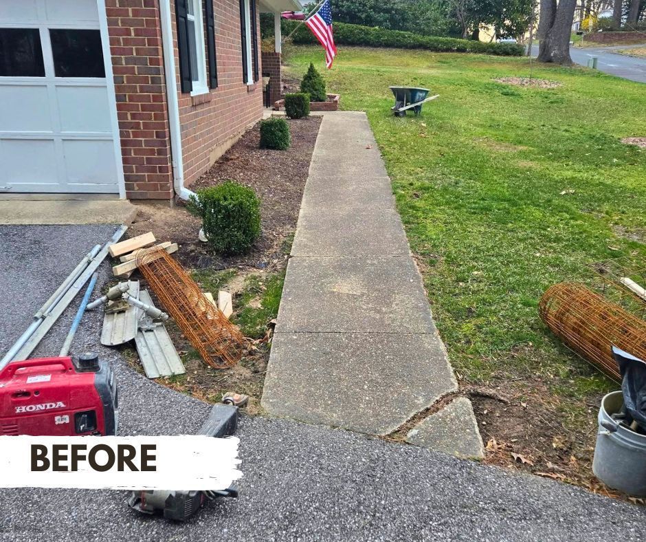 A concrete sidewalk with a large crack, leading from a garage to a front yard. Construction materials and a generator are visible.