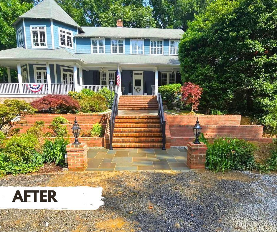 Exterior of a blue Victorian house with brick stairs and terraced landscaping.